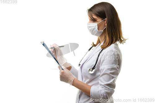 Image of Girl doctor writes with a pen in a tablet computer on a sheet of paper