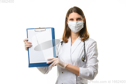 Image of A young girl doctor raised and shows a tablet with a blank sheet of paper in the frame