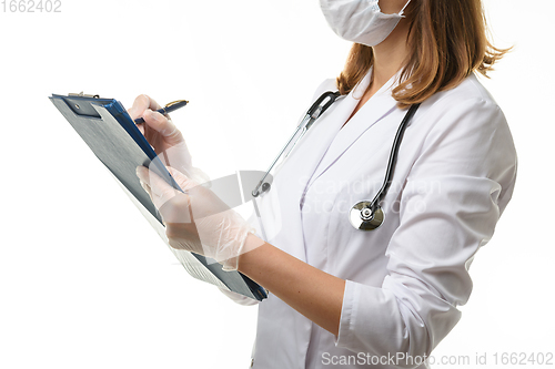 Image of The doctor writes in a clipboard with a ballpoint pen