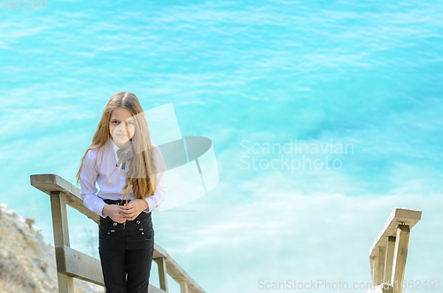 Image of Portrait of a beautiful girl ten years old, in the background a blue-white sea