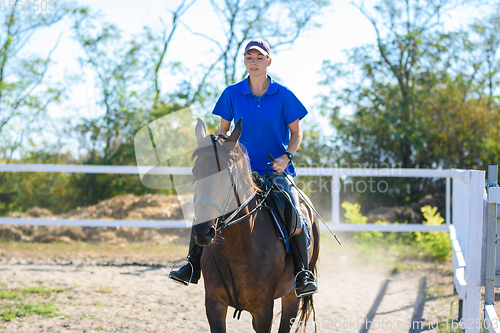 Image of Girl practicing horse riding on a warm summer day