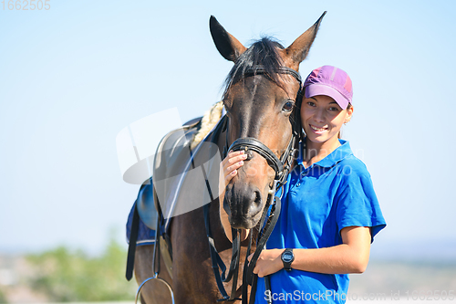 Image of Portrait of a happy beautiful girl in casual clothes hugging a horse