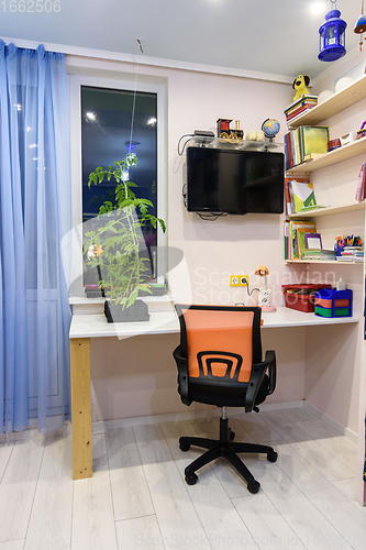 Image of Writing desk in the children\'s room, view of the desk located by the window