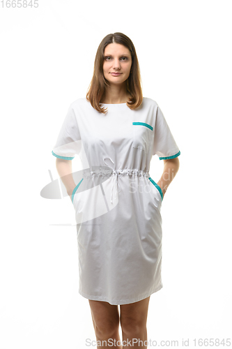 Image of Girl in a white medical coat, hands in pockets, isolated on a white background