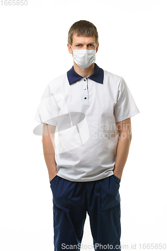 Image of Masked doctor thrust his hands into pockets isolated on white