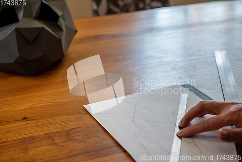 Image of Somebody is making a cube sculpture with paper and linear