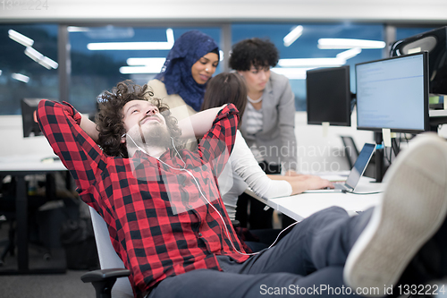 Image of software developer resting with legs on desk