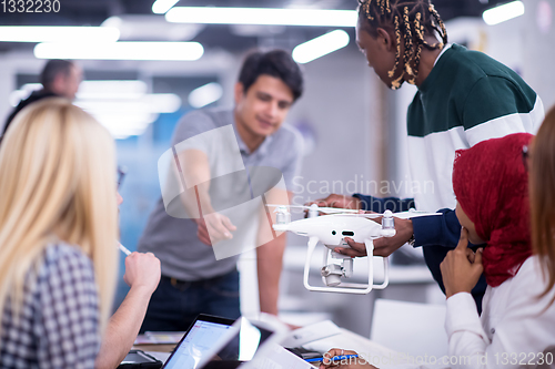 Image of multiethnic business team learning about drone technology