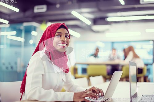 Image of black muslim business woman ,working on laptop computer