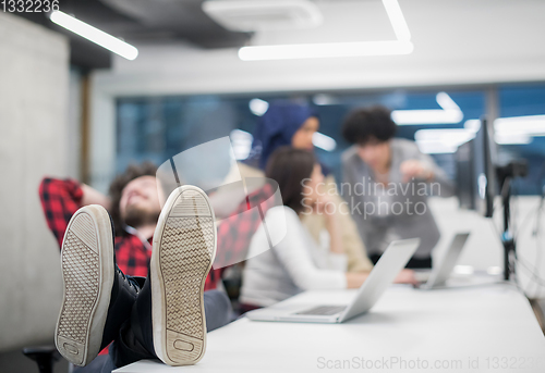 Image of software developer resting with legs on desk