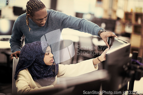 Image of young black muslim female software developer at work