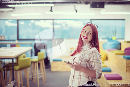 Image of redhead businesswoman using mobile phone at office