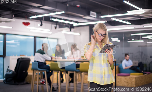 Image of blonde businesswoman working online using digital tablet