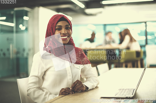 Image of black muslim business woman ,working on laptop computer