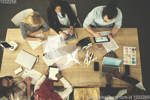 Image of top view of multiethnic business team learning about drone techn