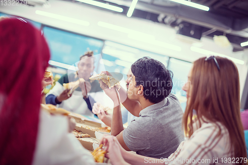 Image of multiethnic business team eating pizza