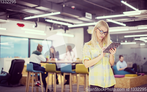 Image of blonde businesswoman working online using digital tablet