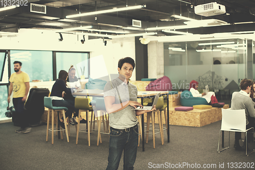 Image of portrait of young indian businessman using laptop computer