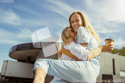 Image of Young lesbian\'s couple preparing for vacation trip on the car in sunny day