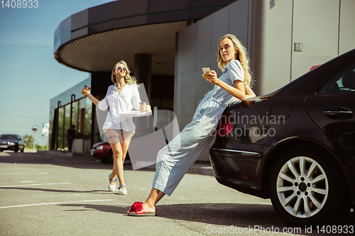 Image of Young lesbian\'s couple preparing for vacation trip on the car in sunny day