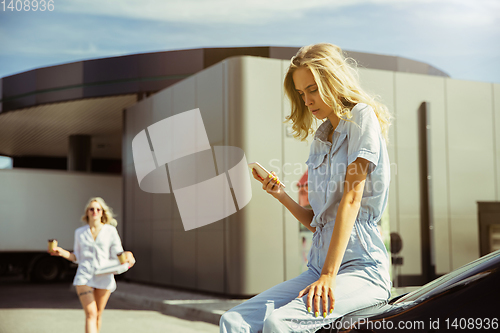 Image of Young lesbian\'s couple preparing for vacation trip on the car in sunny day