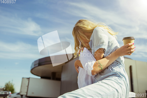 Image of Young lesbian\'s couple preparing for vacation trip on the car in sunny day