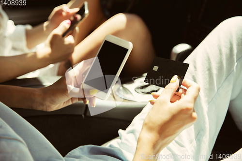 Image of Young lesbian\'s couple preparing for vacation trip on the car in sunny day