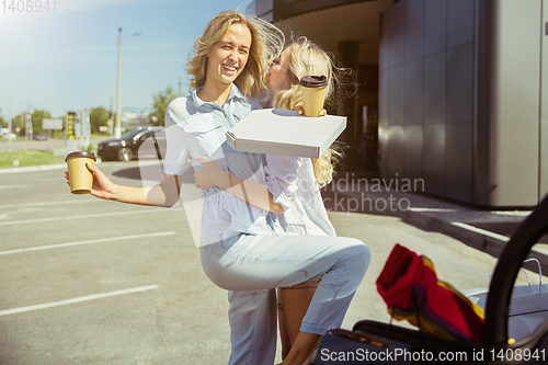 Image of Young lesbian\'s couple preparing for vacation trip on the car in sunny day