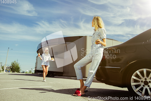 Image of Young lesbian\'s couple preparing for vacation trip on the car in sunny day