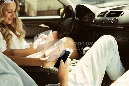 Image of Young lesbian\'s couple preparing for vacation trip on the car in sunny day