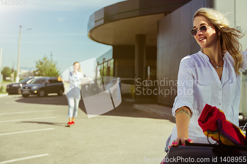 Image of Young lesbian\'s couple preparing for vacation trip on the car in sunny day