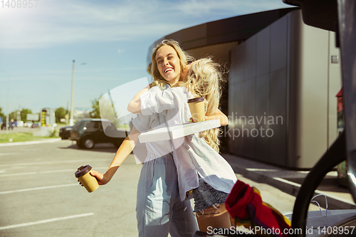 Image of Young lesbian\'s couple preparing for vacation trip on the car in sunny day
