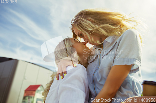 Image of Young lesbian\'s couple preparing for vacation trip on the car in sunny day