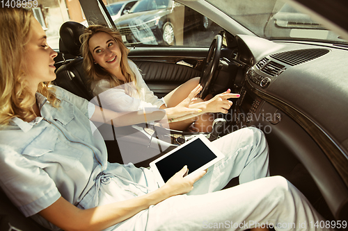 Image of Young lesbian\'s couple preparing for vacation trip on the car in sunny day