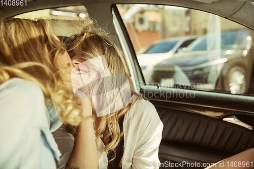 Image of Young lesbian\'s couple preparing for vacation trip on the car in sunny day