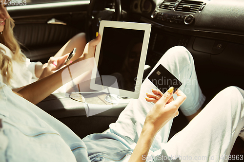 Image of Young lesbian\'s couple preparing for vacation trip on the car in sunny day