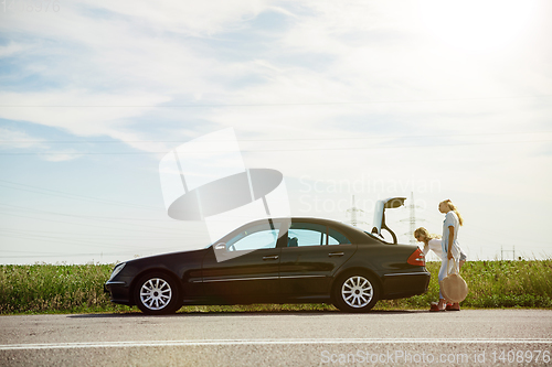 Image of Young lesbian\'s couple going to vacation trip on the car in sunny day