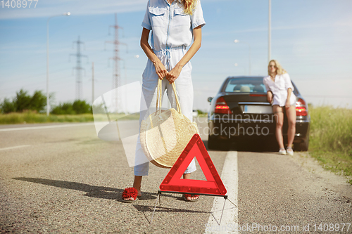 Image of Young lesbian\'s couple going to vacation trip on the car in sunny day