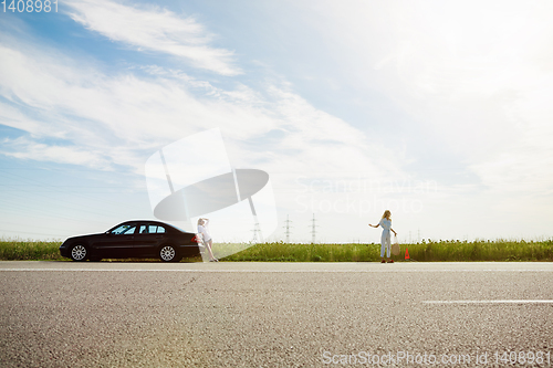 Image of Young lesbian\'s couple going to vacation trip on the car in sunny day