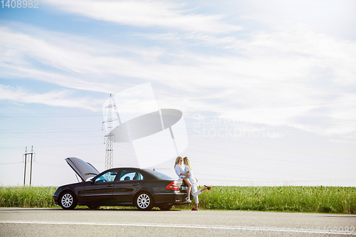 Image of Young lesbian\'s couple going to vacation trip on the car in sunny day