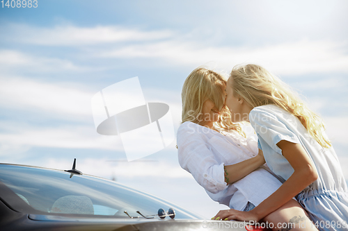 Image of Young lesbian\'s couple going to vacation trip on the car in sunny day