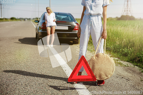 Image of Young lesbian\'s couple going to vacation trip on the car in sunny day