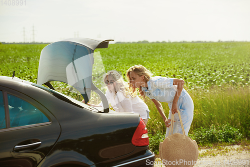 Image of Young lesbian\'s couple going to vacation trip on the car in sunny day