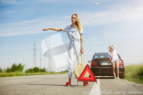 Image of Young lesbian\'s couple going to vacation trip on the car in sunny day