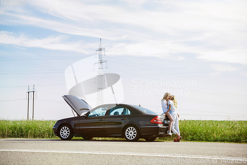 Image of Young lesbian\'s couple going to vacation trip on the car in sunny day