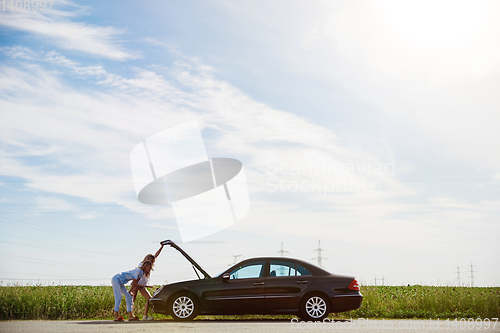 Image of Young lesbian\'s couple going to vacation trip on the car in sunny day