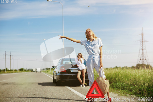 Image of Young lesbian\'s couple going to vacation trip on the car in sunny day