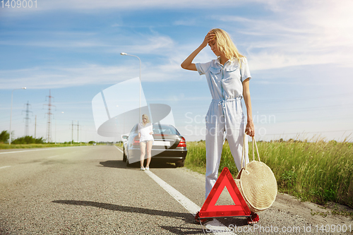 Image of Young lesbian\'s couple going to vacation trip on the car in sunny day