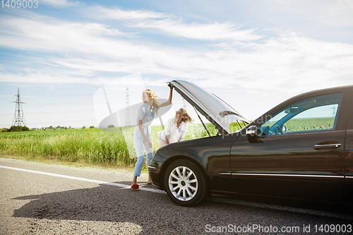 Image of Young lesbian\'s couple going to vacation trip on the car in sunny day