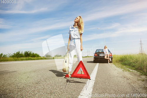 Image of Young lesbian\'s couple going to vacation trip on the car in sunny day